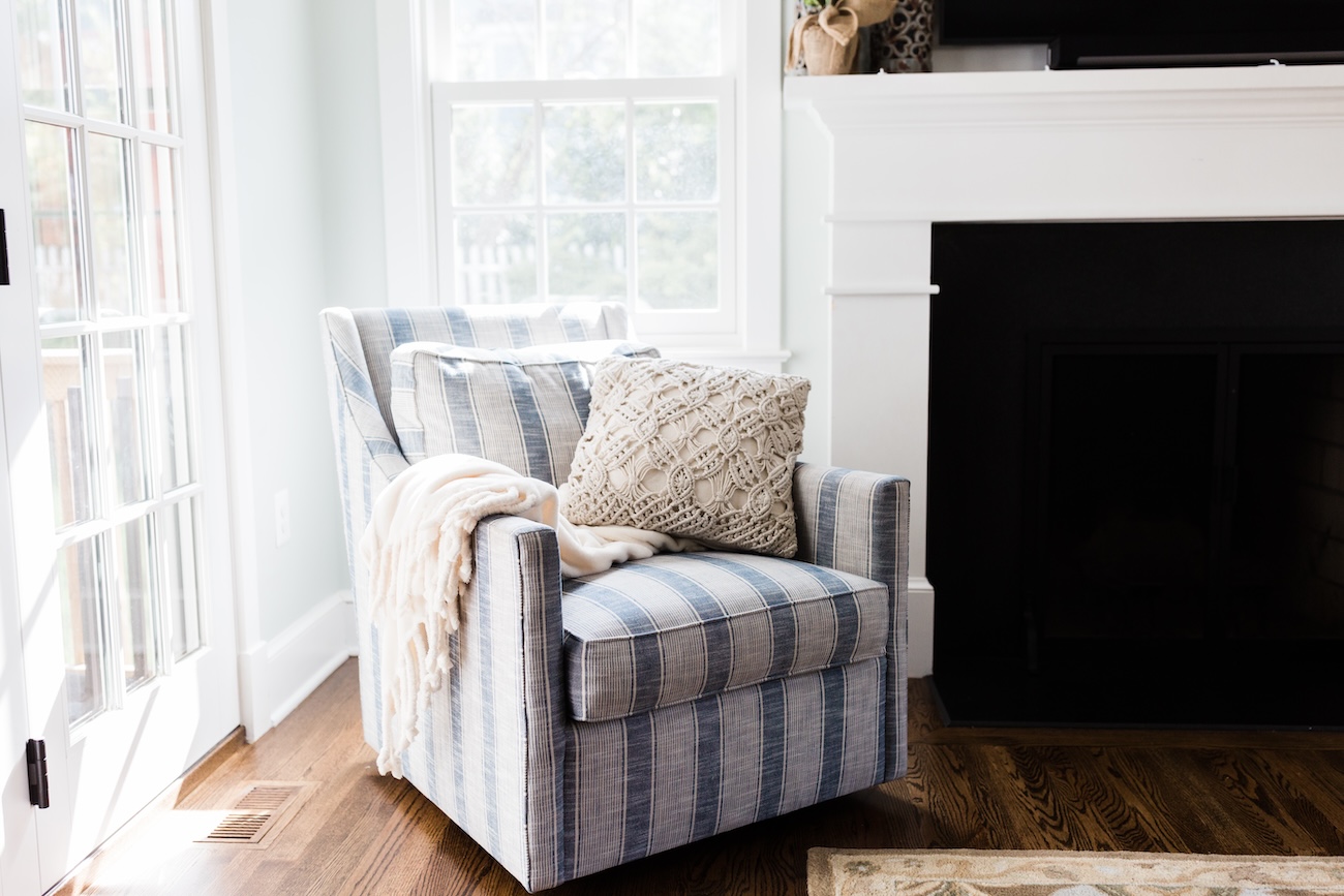 fireplace-striped-armchair-cream-accent-pillows-throw